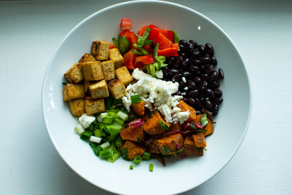 high protein tofu black bean bowl with lettuce and sweet potato