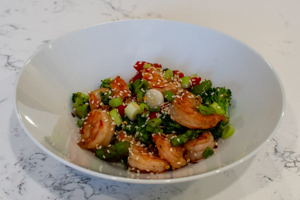 close-up of low carb shrimp stir fry garnished with sesame seeds and green onion