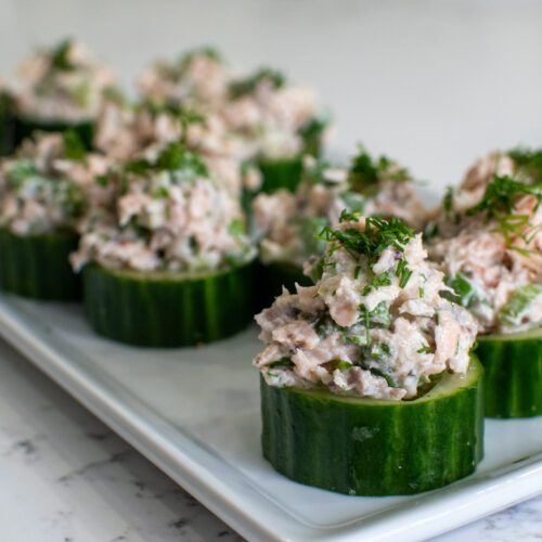 Flaked salmon salad with asparagus served in cucumber cups, garnished with dill and lemon zest